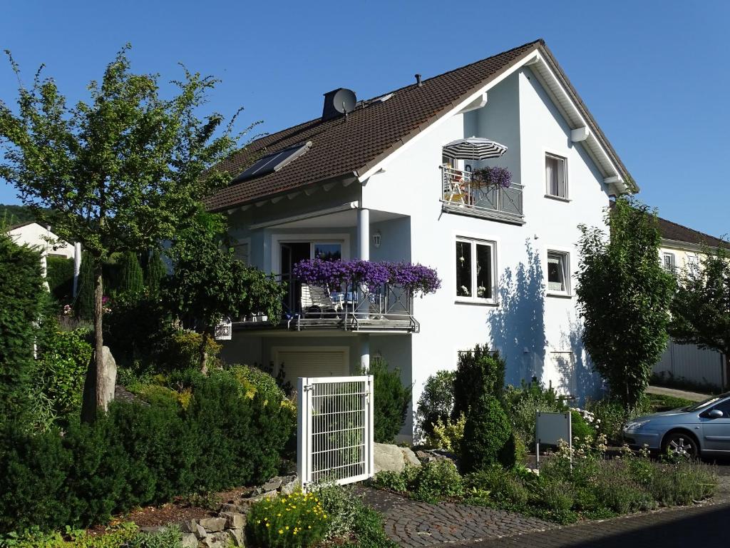 a white house with a white gate and flowers at Gästehaus Cilli Freimuth in Ellenz-Poltersdorf