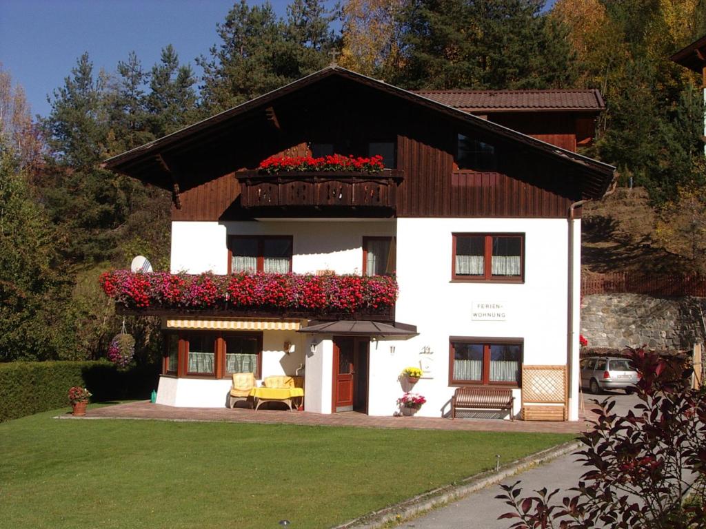 Casa blanca con balcón con flores rojas en Haus Gantioler, en Mieders