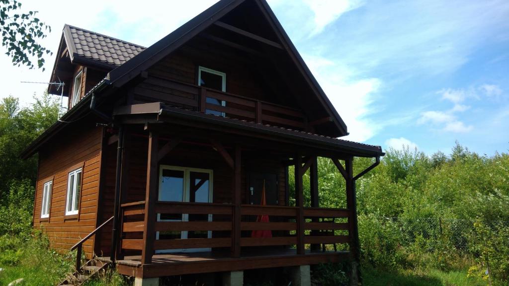 a log cabin with a black roof at Domek nad morzem Mechowo in Mechowo