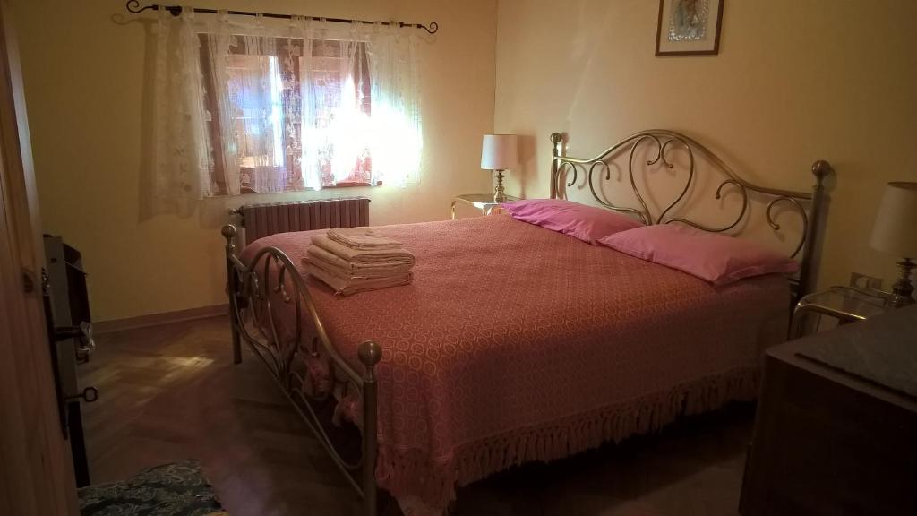 1 dormitorio con 1 cama con manta roja y ventana en La mansarda sul fiume, en Abetone