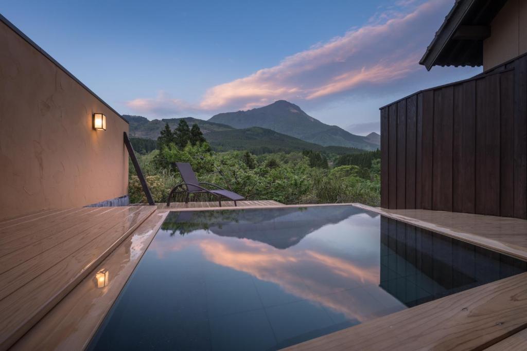 a swimming pool with a view of the mountains at Ikkoten in Yufuin