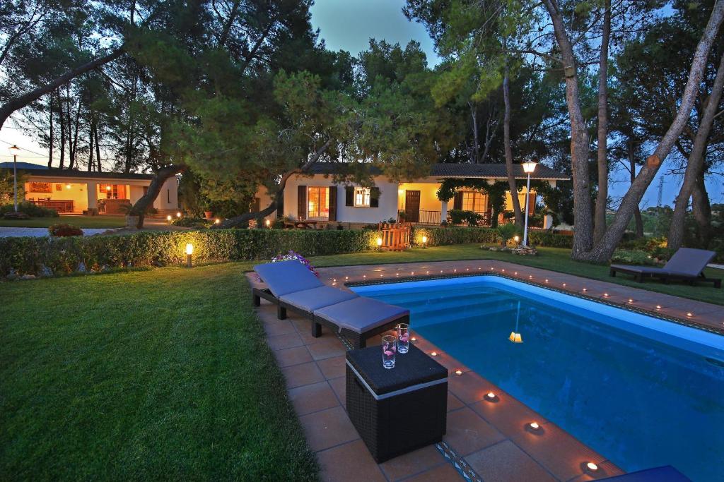 a backyard with a swimming pool and a house at Casa Rural Els Pins in Sant Marçal