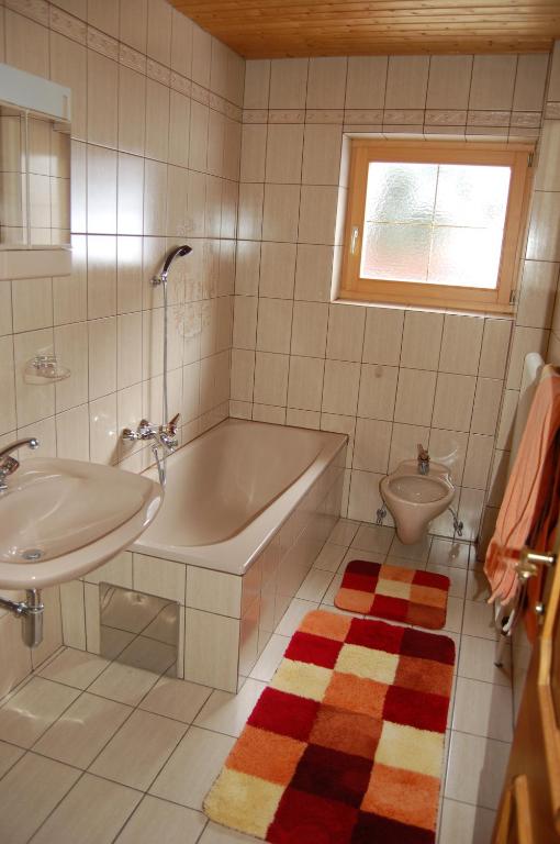 a bathroom with a tub and a sink and a toilet at Haus Gantioler in Mieders