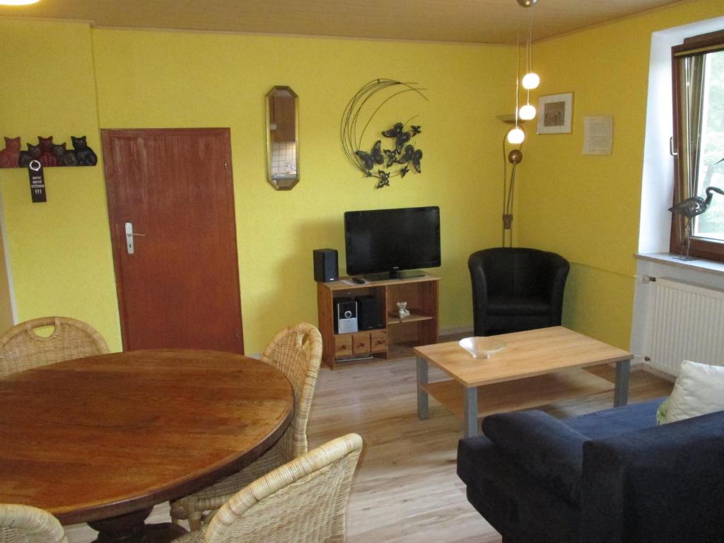 ein Wohnzimmer mit einem Tisch und einem TV in der Unterkunft Altes Zollhaus Nähe Luxemburg in Ammeldingen