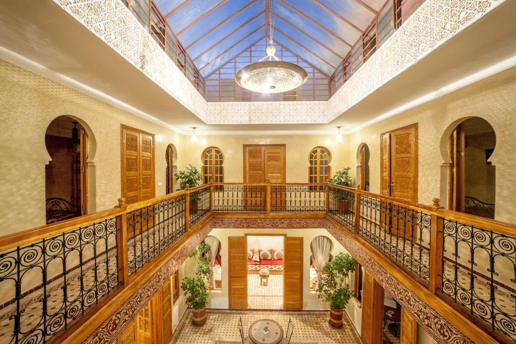 un grand couloir avec des balustrades en bois et un plafond dans l'établissement Riad Dar Saidi, à Rabat