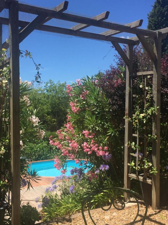 uma pérgola e uma piscina com flores em Warblers View em Biot
