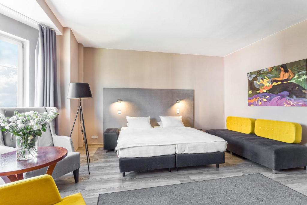 pokój hotelowy z łóżkiem i kanapą w obiekcie Hotel Kaliski w Słubicach