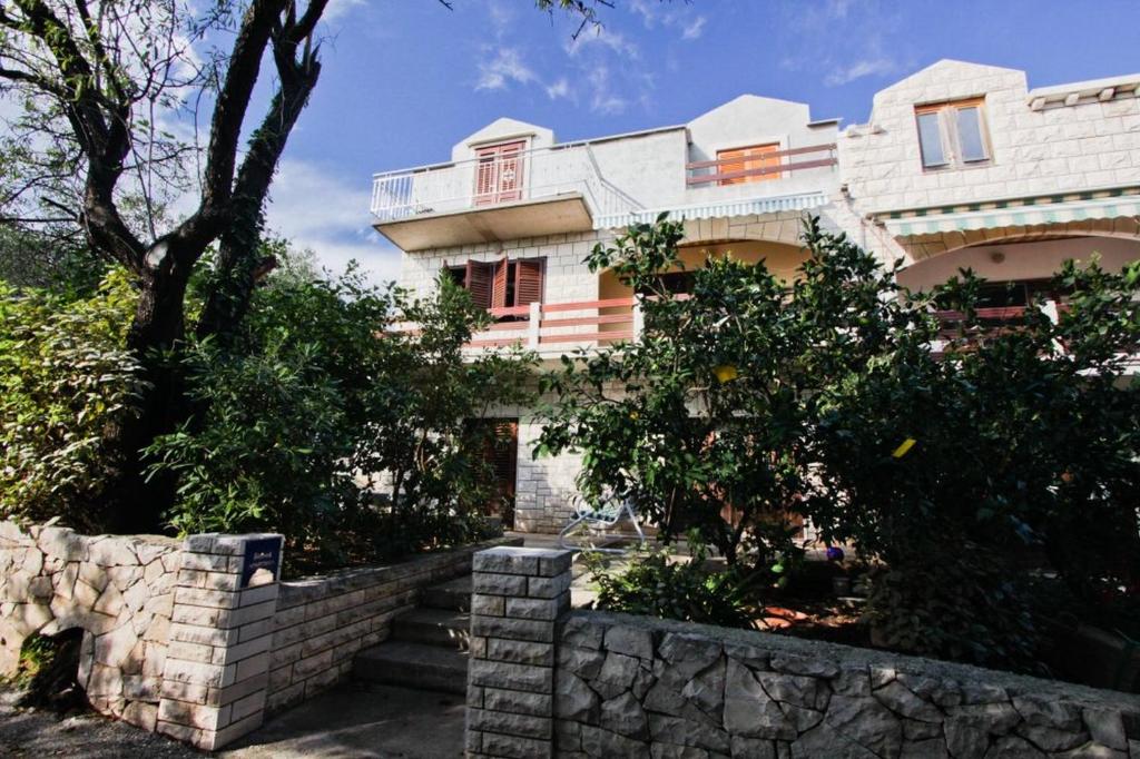 a building with a stone retaining wall in front of it at Apartments Stanko in Sumartin