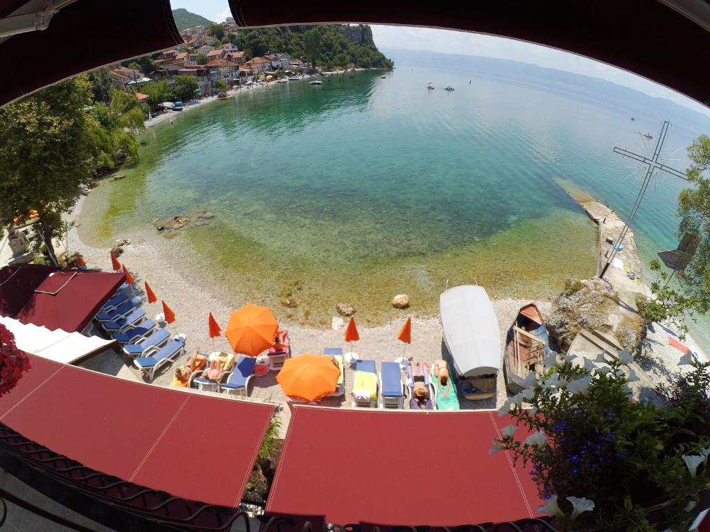Blick auf einen Strand mit Stühlen und Sonnenschirmen in der Unterkunft Villa Marko - Trpejca in Ohrid
