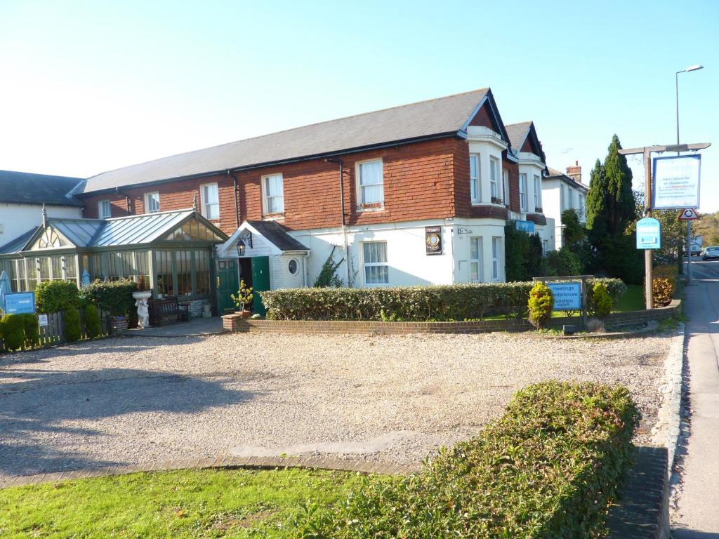 a large brick house with a gravel driveway at Arundel Park Hotel in Arundel