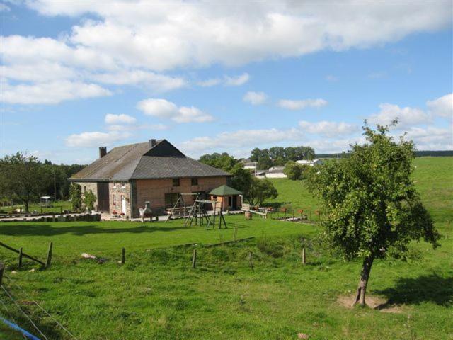 a house in the middle of a field with a tree at Sol Battire in Brisy