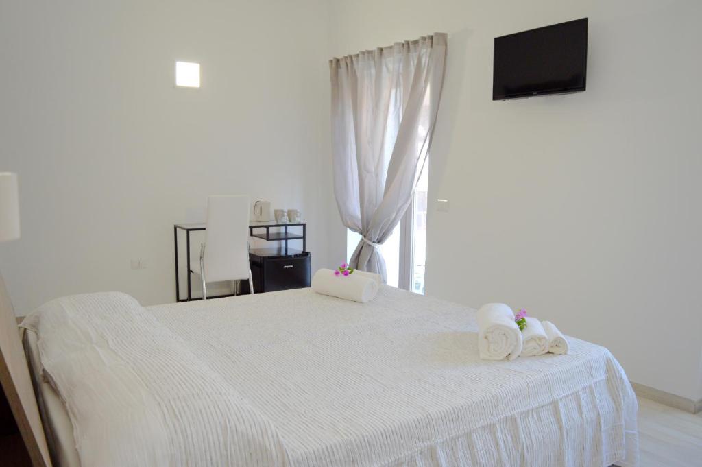 a bedroom with a white bed with towels on it at Il S'Ogno in Santa Teresa Gallura