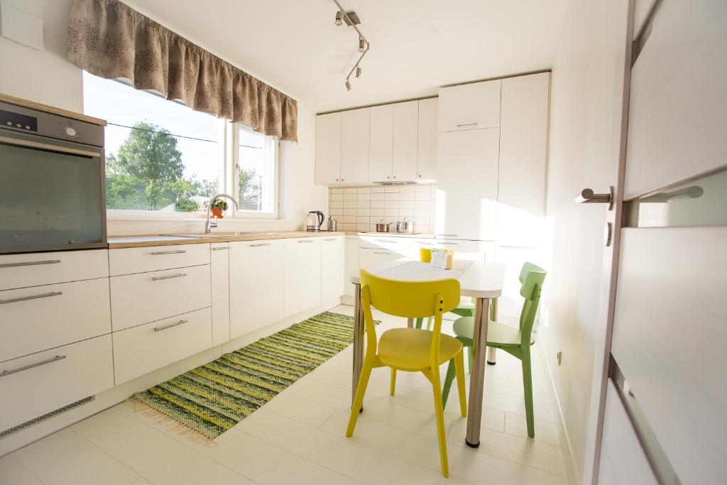 a kitchen with a small table and yellow chairs at Tamme Flint in Tartu