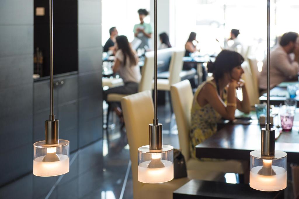 a woman sitting at a table in a restaurant at Vila Galé Estoril in Estoril