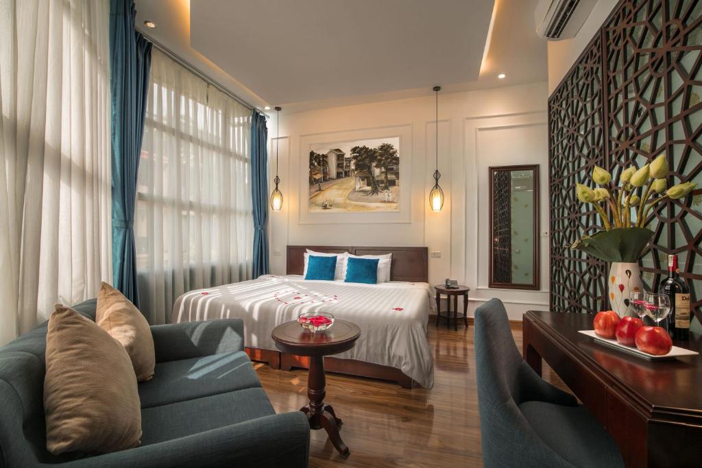 a hotel room with a bed and a couch at Hanoi Chic Boutique Hotel in Hanoi