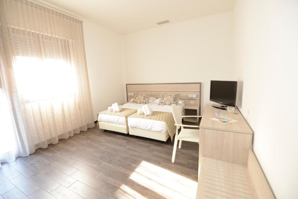 Schlafzimmer mit einem Bett und einem Schreibtisch mit einem TV in der Unterkunft BB Venice Cinzias' in Marghera