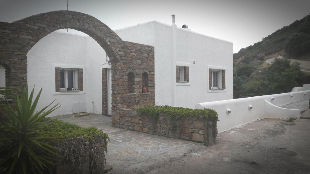a white building with an archway in front of it at Erifili Homes in Agioi Apostoli
