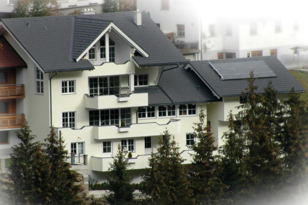 a white building with a black roof at Apart Avenzio in Kappl