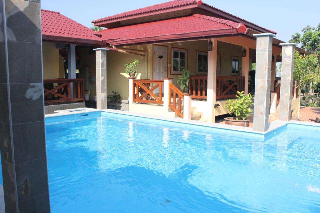 a large blue swimming pool in front of a house at Rimlay Park Resort in Phatthalung