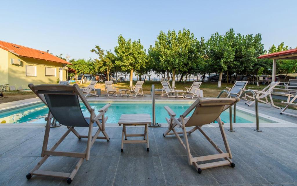 a group of chairs sitting next to a swimming pool at Camping Valti Houses in Sarti