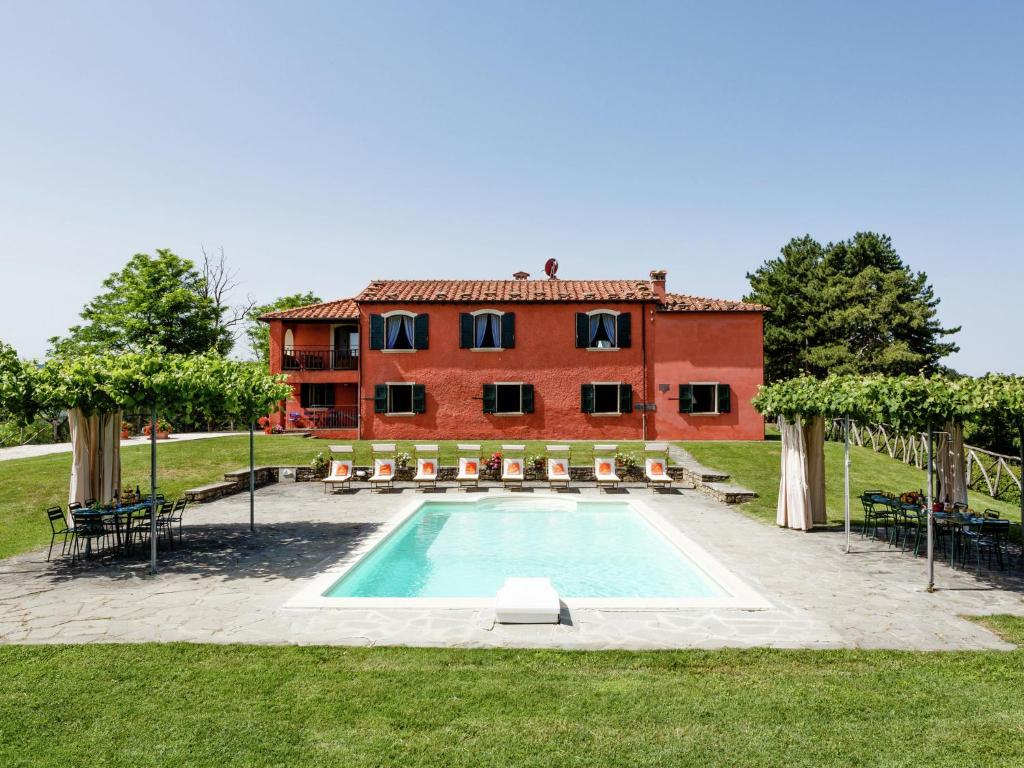 a house with a swimming pool in front of a building at Expansive Villa in Tredozio Tuscany with Panoramic Views in Tredozio