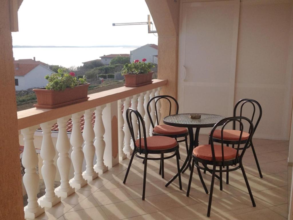 a balcony with a table and chairs and a window at Apartment in Rtina&#47;Zadar Riviera 8160 in Miočić