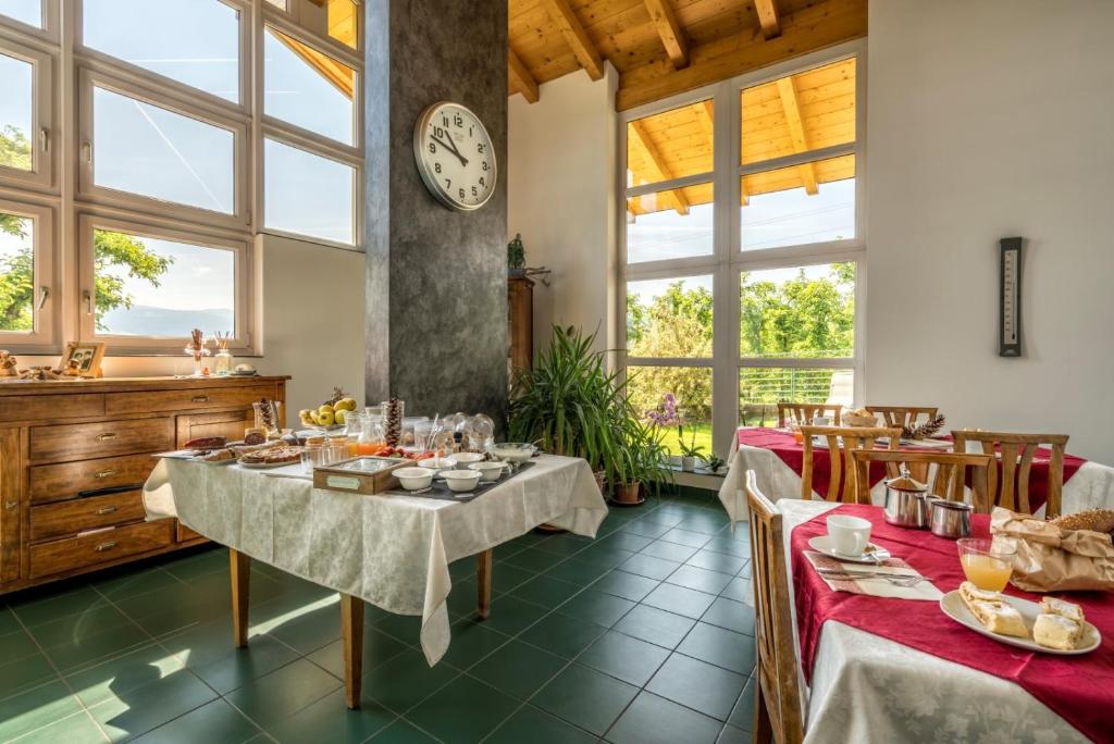 un comedor con 2 mesas y un reloj en la pared en Agritur Deromedi, en Cles