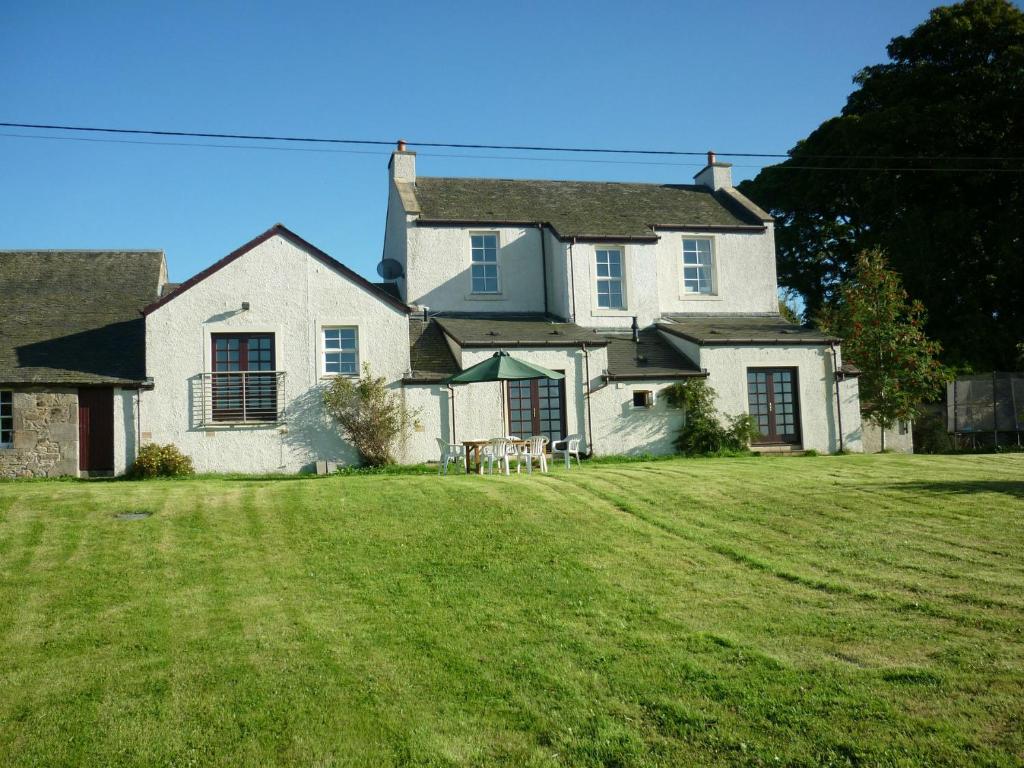 duży biały dom z dużym dziedzińcem w obiekcie Midkinleith Farm Holiday Cottage w Edynburgu