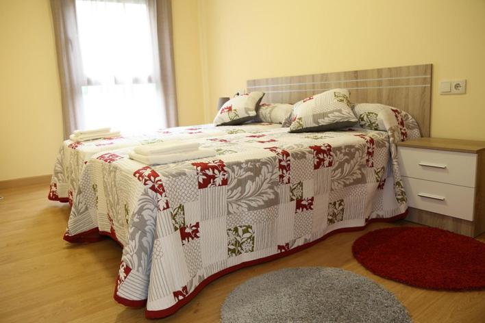 a bedroom with a bed with a red and white blanket at Alojamiento Caldas de Reis in Caldas de Reis