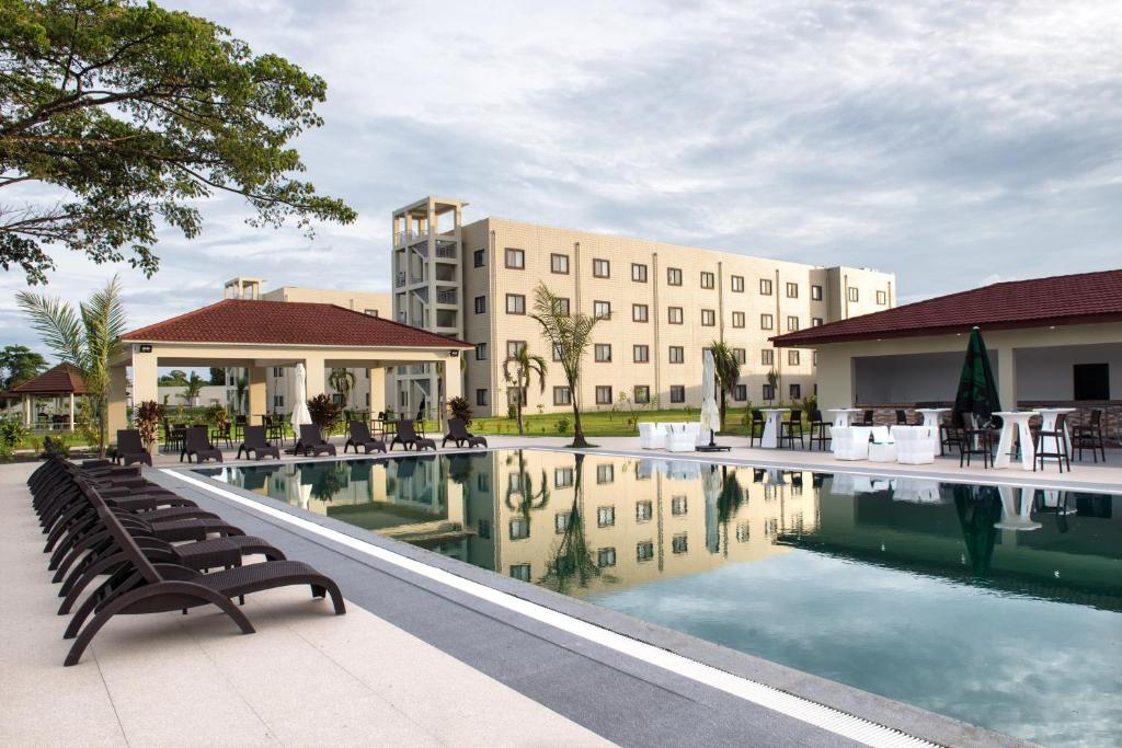 un hotel con piscina frente a un edificio en The Farmington Hotel en Harbel