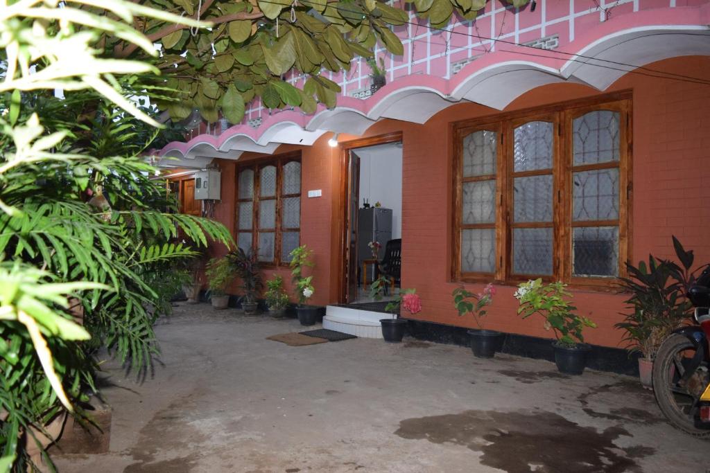 a building with windows and potted plants in it at Nest Inn in Trincomalee