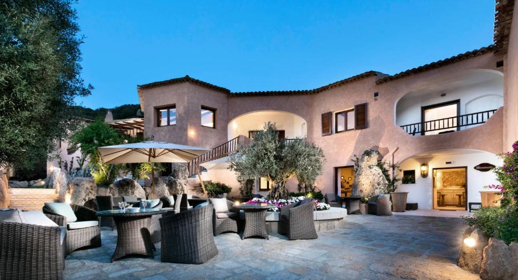 a patio with chairs and tables in front of a building at Relais Villa Carola in Porto Cervo