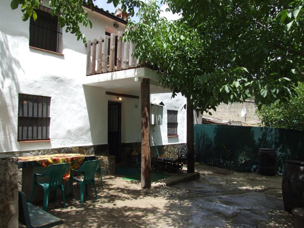 een huis met een tafel en stoelen in een tuin bij Casa La Rosa P.N. Sierra de Grazalema in Benamahoma