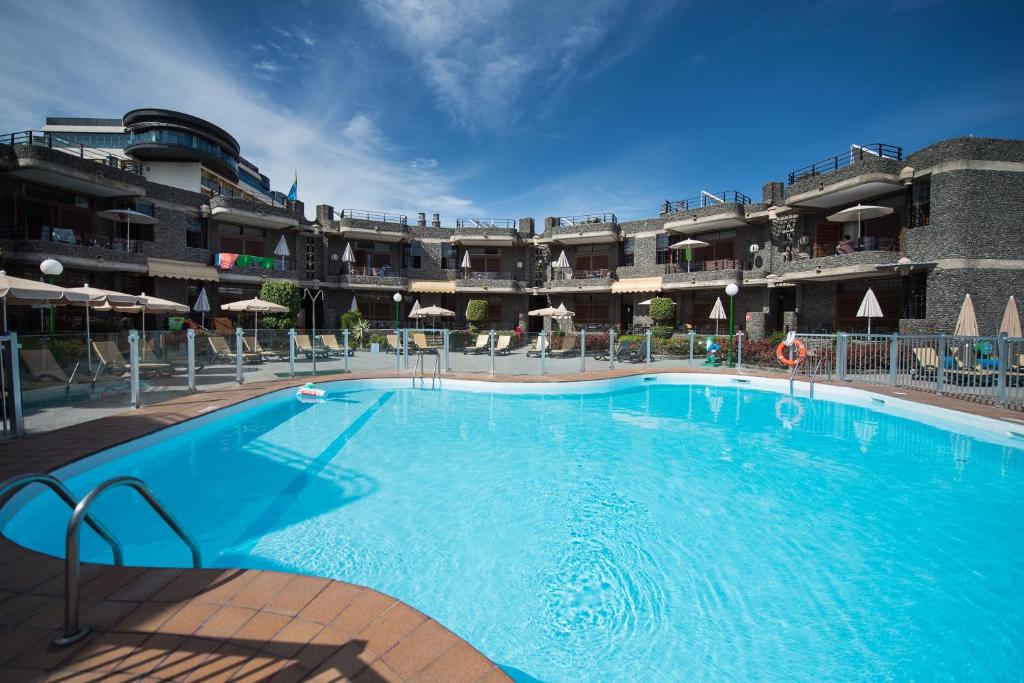 una gran piscina frente a un edificio en Apartamentos Don Pedro, en Playa del Inglés