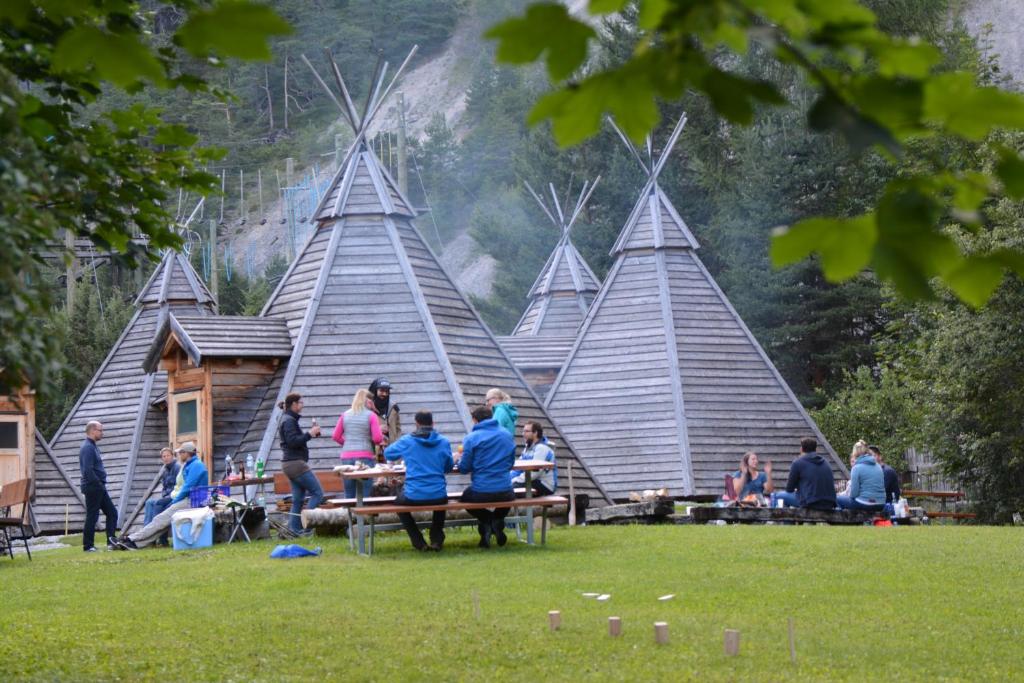グレーブミングにあるTipi Dorf Gröbmingのピラミッドの家の前に座る人々