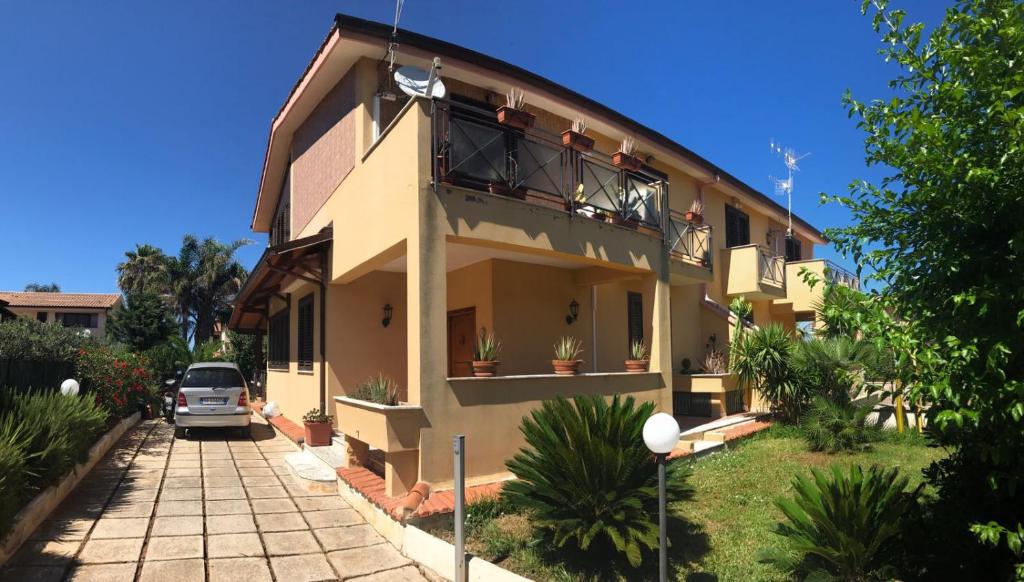 a house with a car parked in front of it at Stunning Sicilian Villa in Carini
