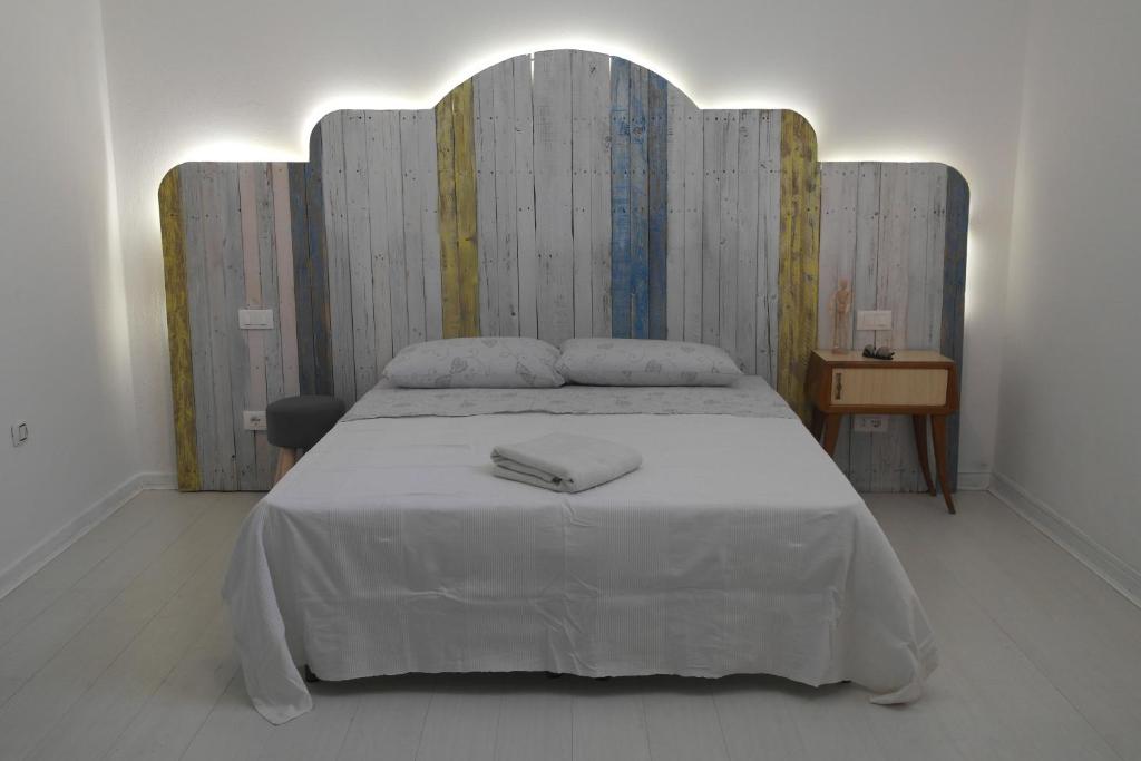 a bedroom with a large bed with a wooden headboard at My Eco Rooms Olbia in Olbia