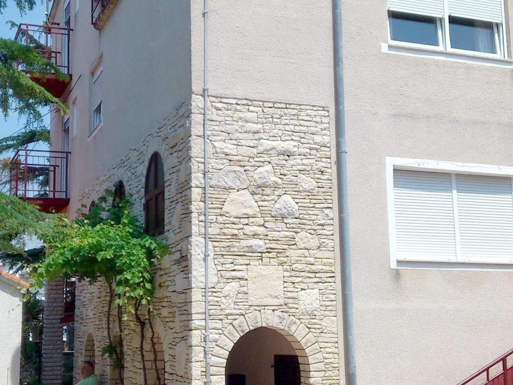a building with an archway on the side of it at Apartment Medulin 10 in Medulin