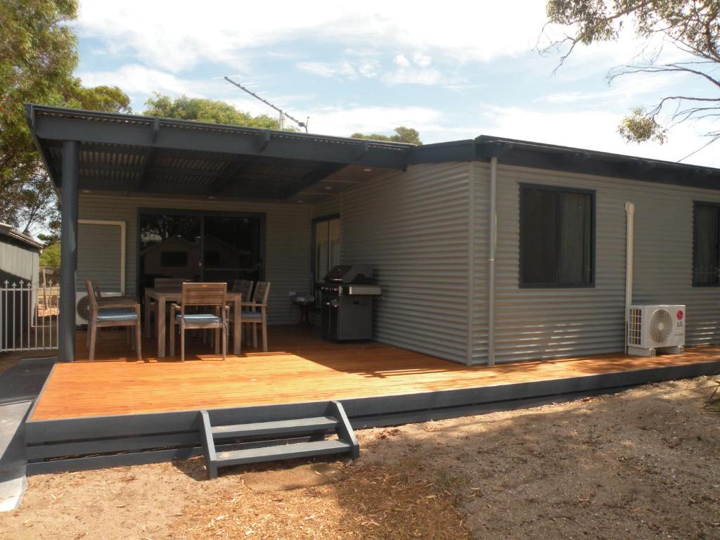 a house with a deck with a table and a patio at The Anchorage Cottage Kangaroo Island in American River