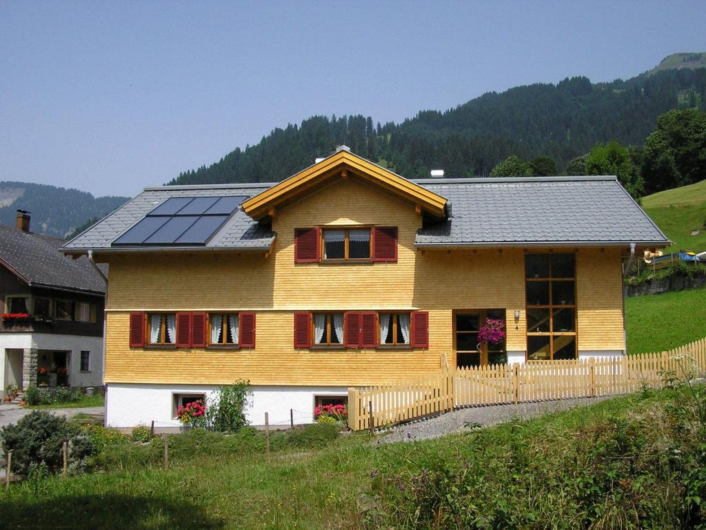 ein Haus mit Sonnenkollektoren darüber in der Unterkunft Appartement Bischof in Schoppernau