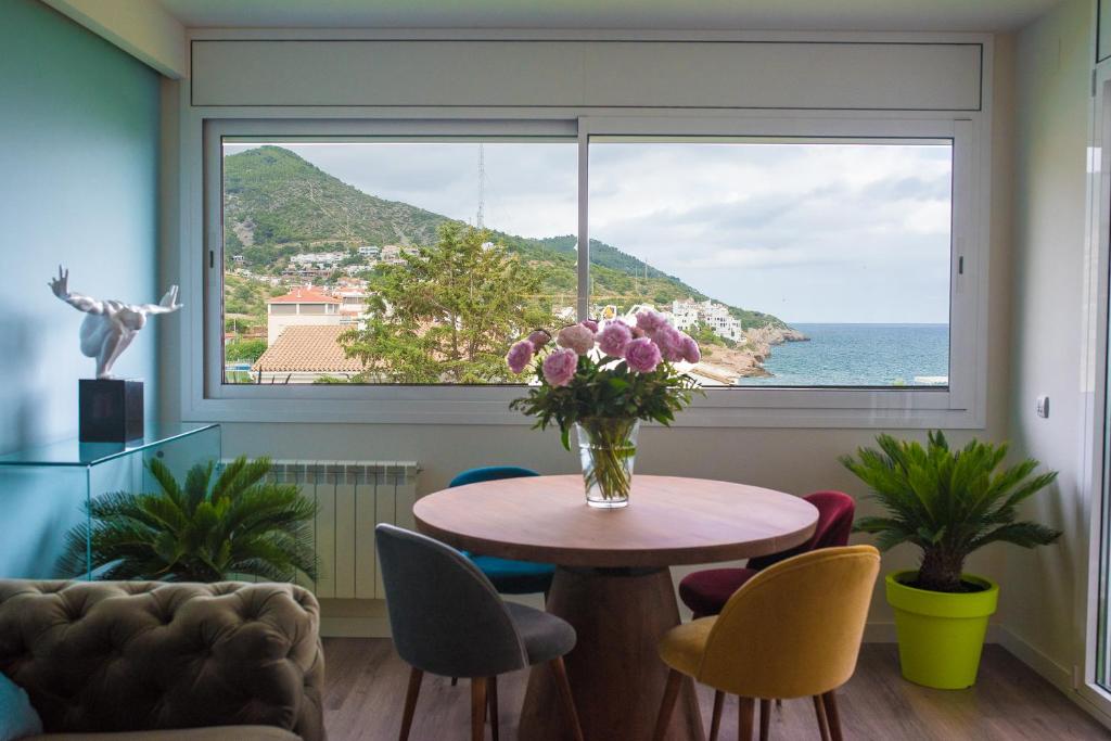 ein Esszimmer mit einem Tisch und einem großen Fenster in der Unterkunft La Marina de Aiguadolç in Sitges