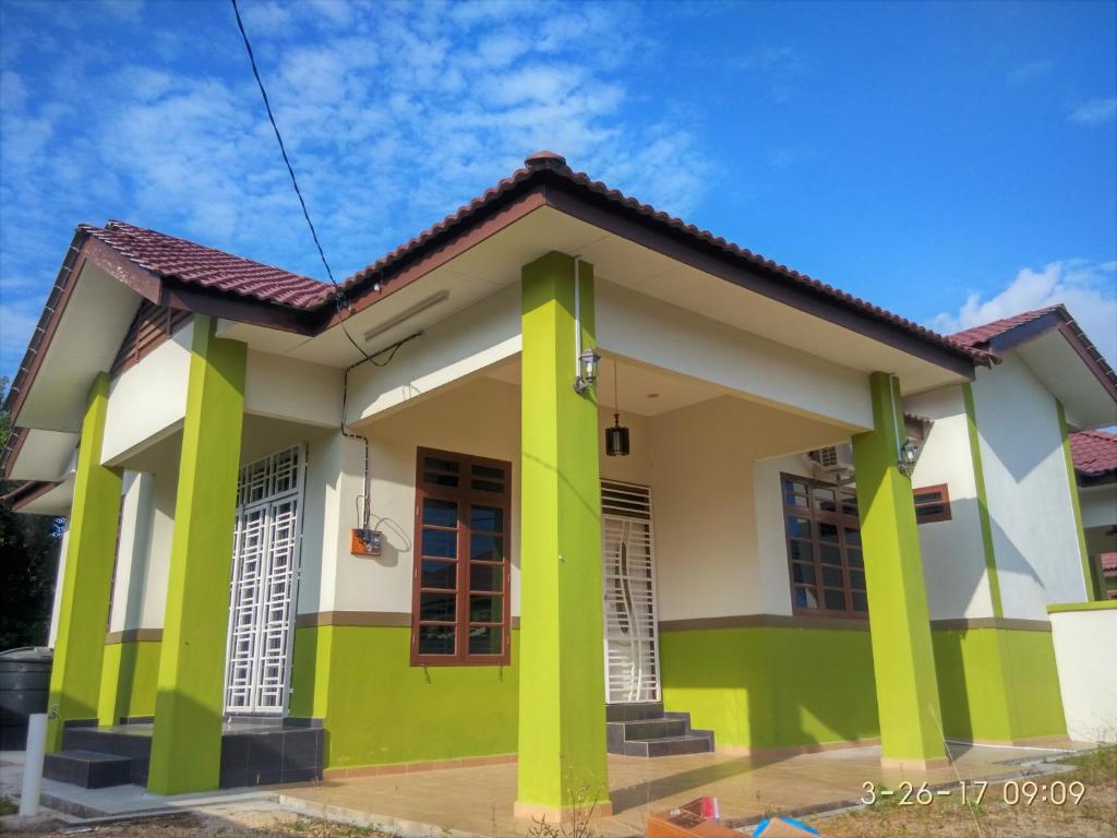 een huis met groene en witte verf bij PCB Homestay in Kota Bharu