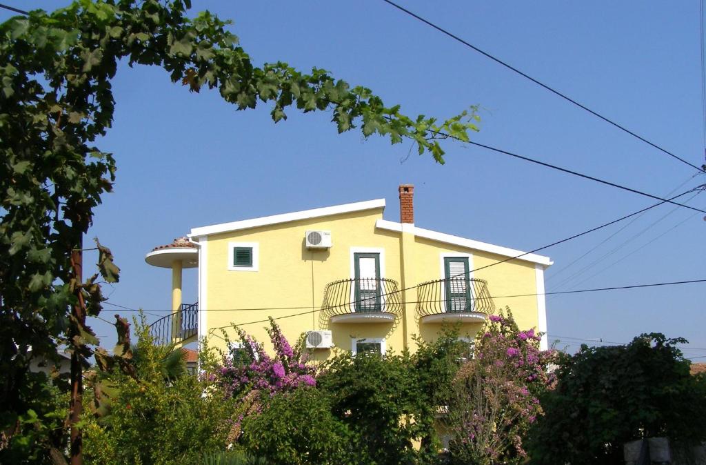 a yellow house with balconies on the side of it at Apartment Kukljica 7 in Kukljica