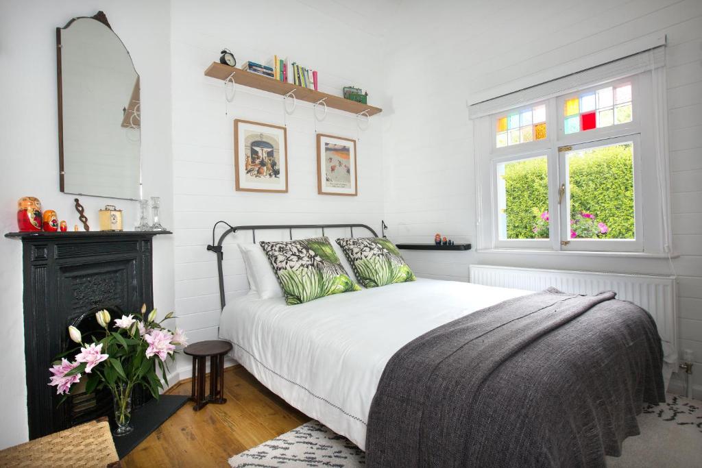 a white bedroom with a bed and a window at The Dolls House in Wexford