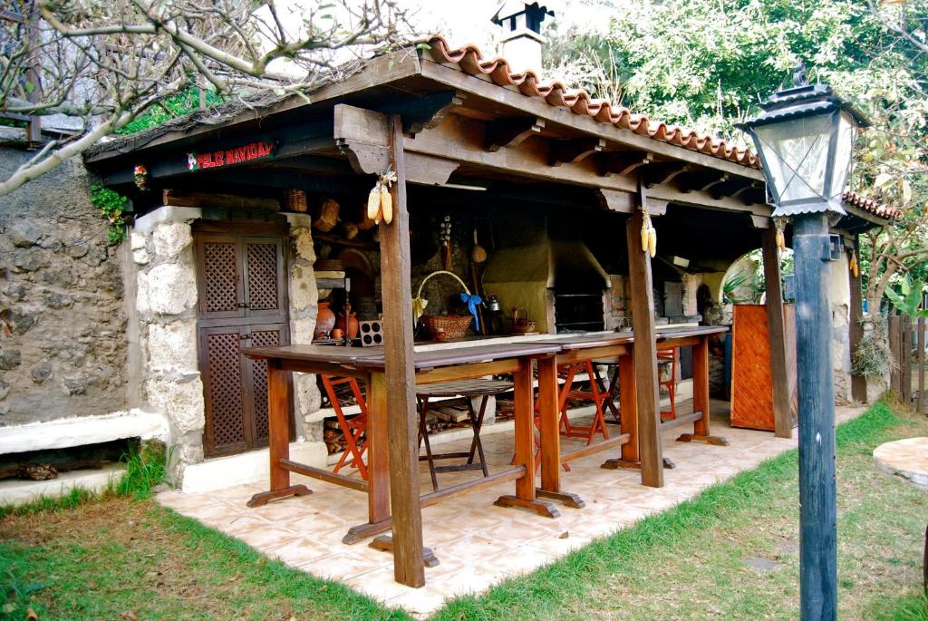 eine Außenküche mit einem Holztisch in einem Haus in der Unterkunft Casa Rural de Tío Félix in Vega de San Mateo