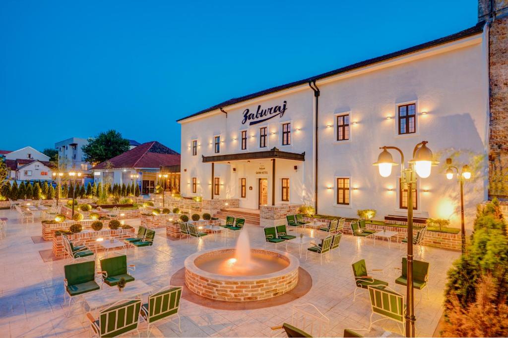 ein Hotel mit einem Brunnen vor einem Gebäude in der Unterkunft Garni Hotel Zavicaj in Belgrad