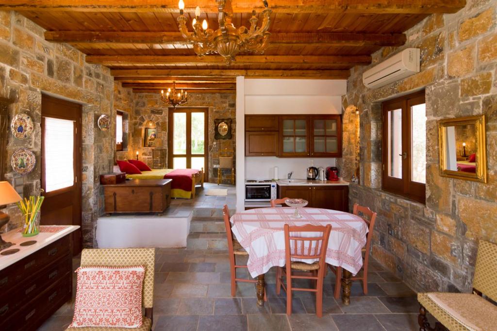 kuchnia i salon ze stołem i krzesłami w obiekcie Athena Villas Olive Grove & Estate w mieście Guwes