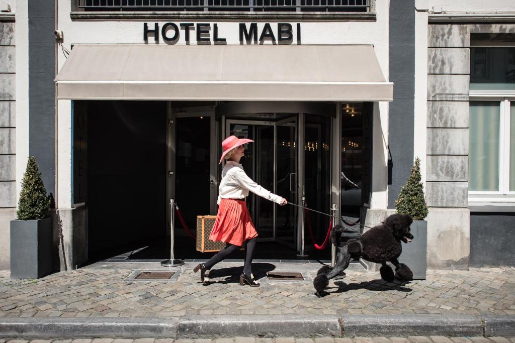a woman walking a dog on a leash at Mabi City Centre Hotel in Maastricht