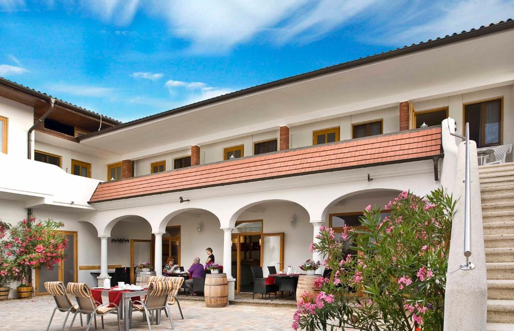 a building with chairs and a table in front of it at Weingut Franz Schindler in Mörbisch am See