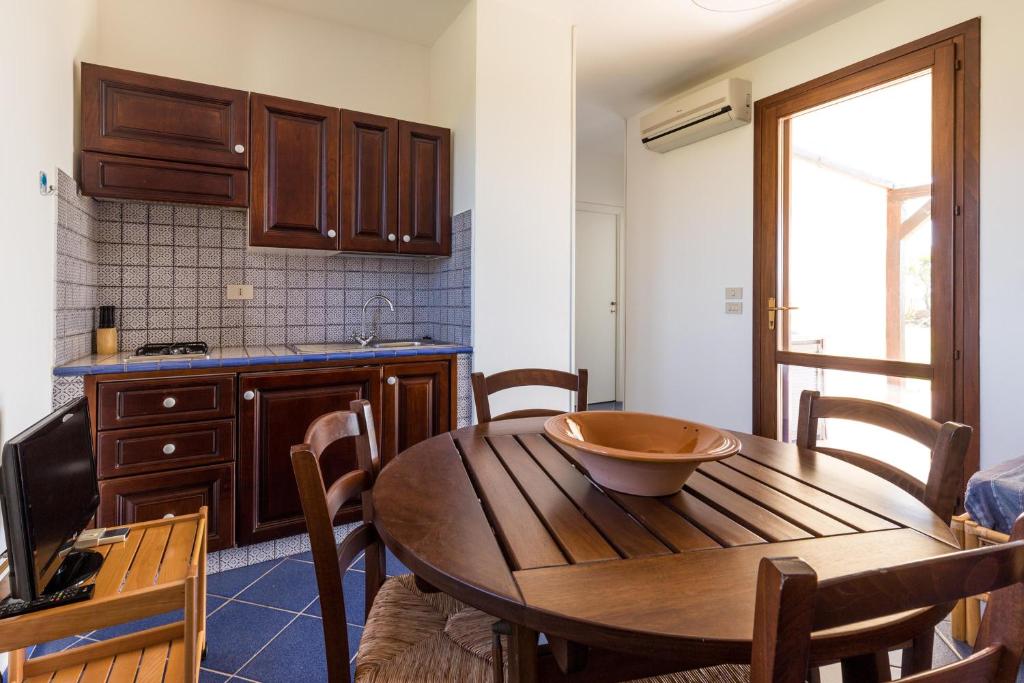 a kitchen with a wooden table with a bowl on it at Le Casette a Favignana in Favignana